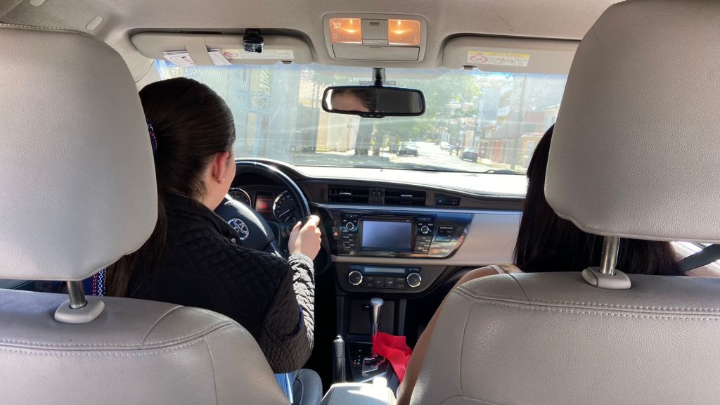 Mulher dirigindo e mulher como passageira, no carro.