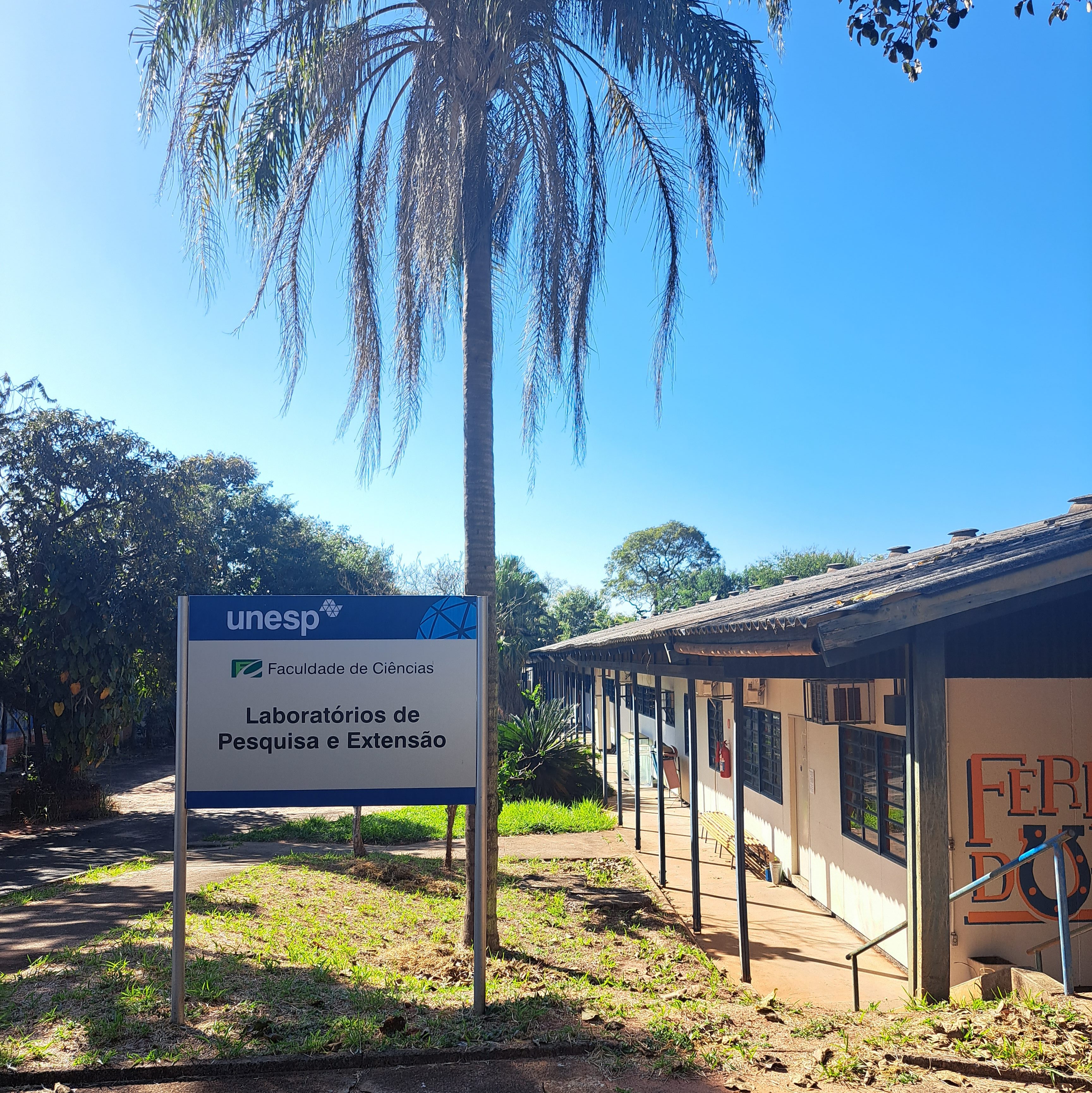 A imagem apresenta uma placa identificando a localização dos Laboratórios de Pesquisa e Extensão da UNESP.