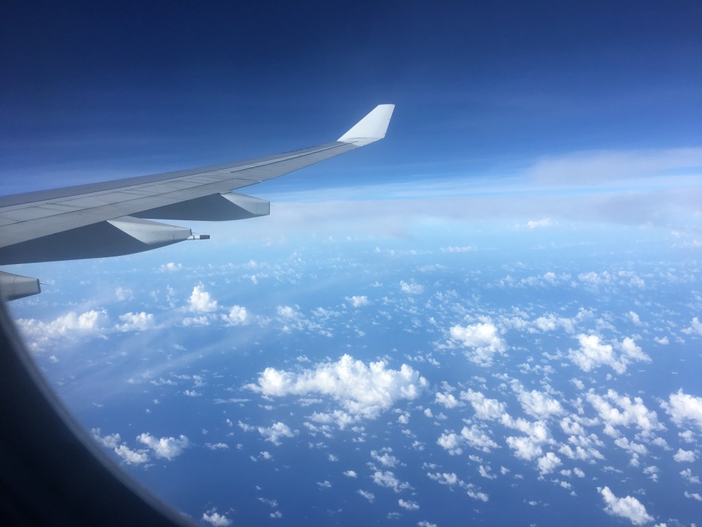 Asas de avião no céu sob as nuvens